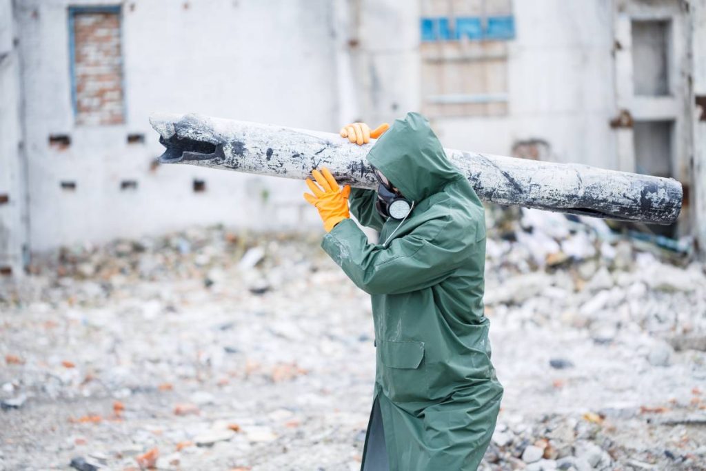 A man in a protective mask and protective clothing explores the danger zone. Ecological catastrophe. selective focus